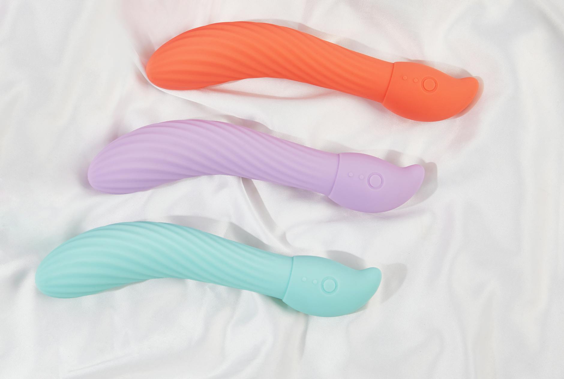 Woman holding vibrators in contemplative pose while managing pelvic wellness