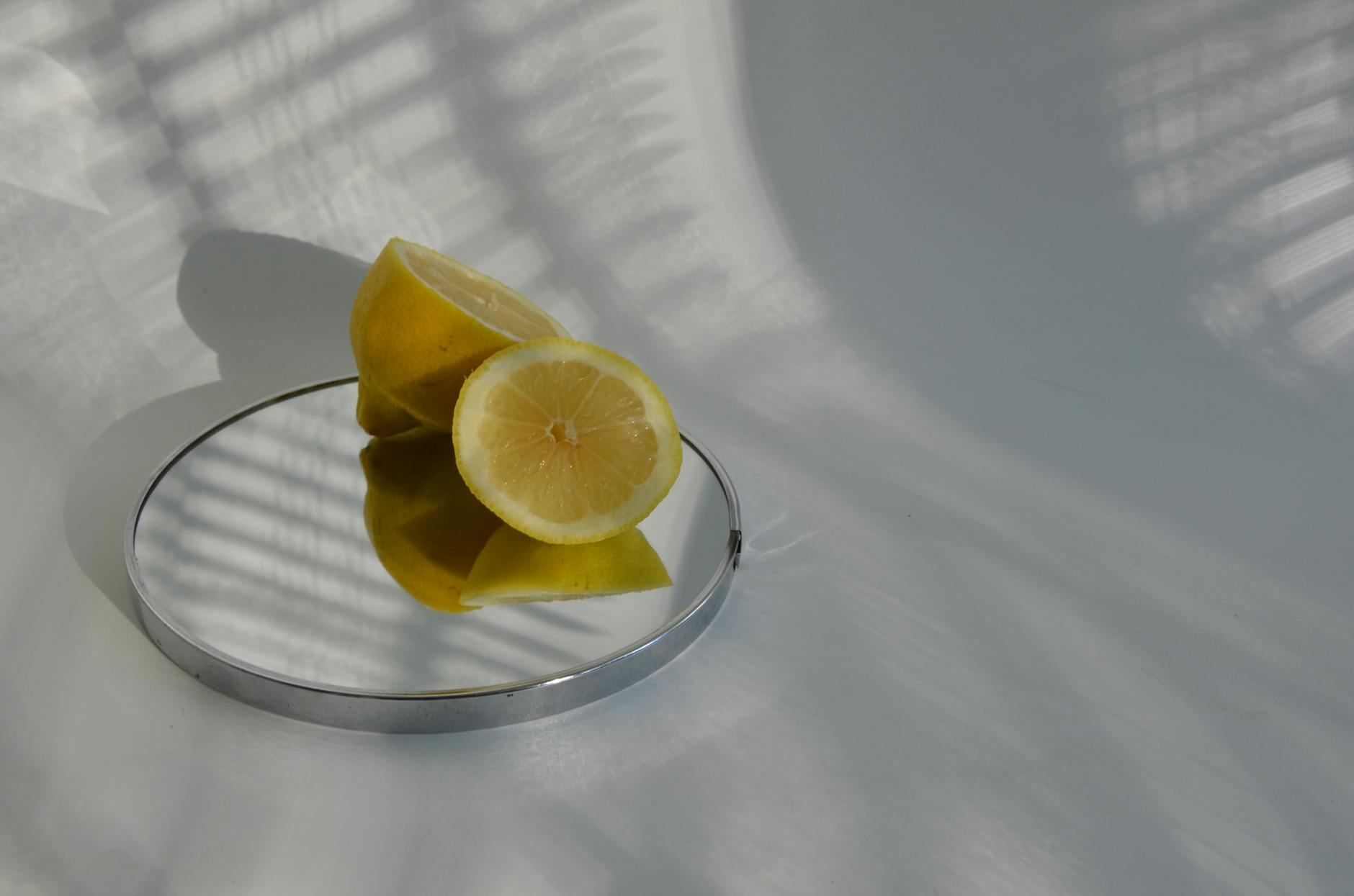 Hand holding a fresh lemon against a vibrant yellow background, symbolizing renewal and freshness