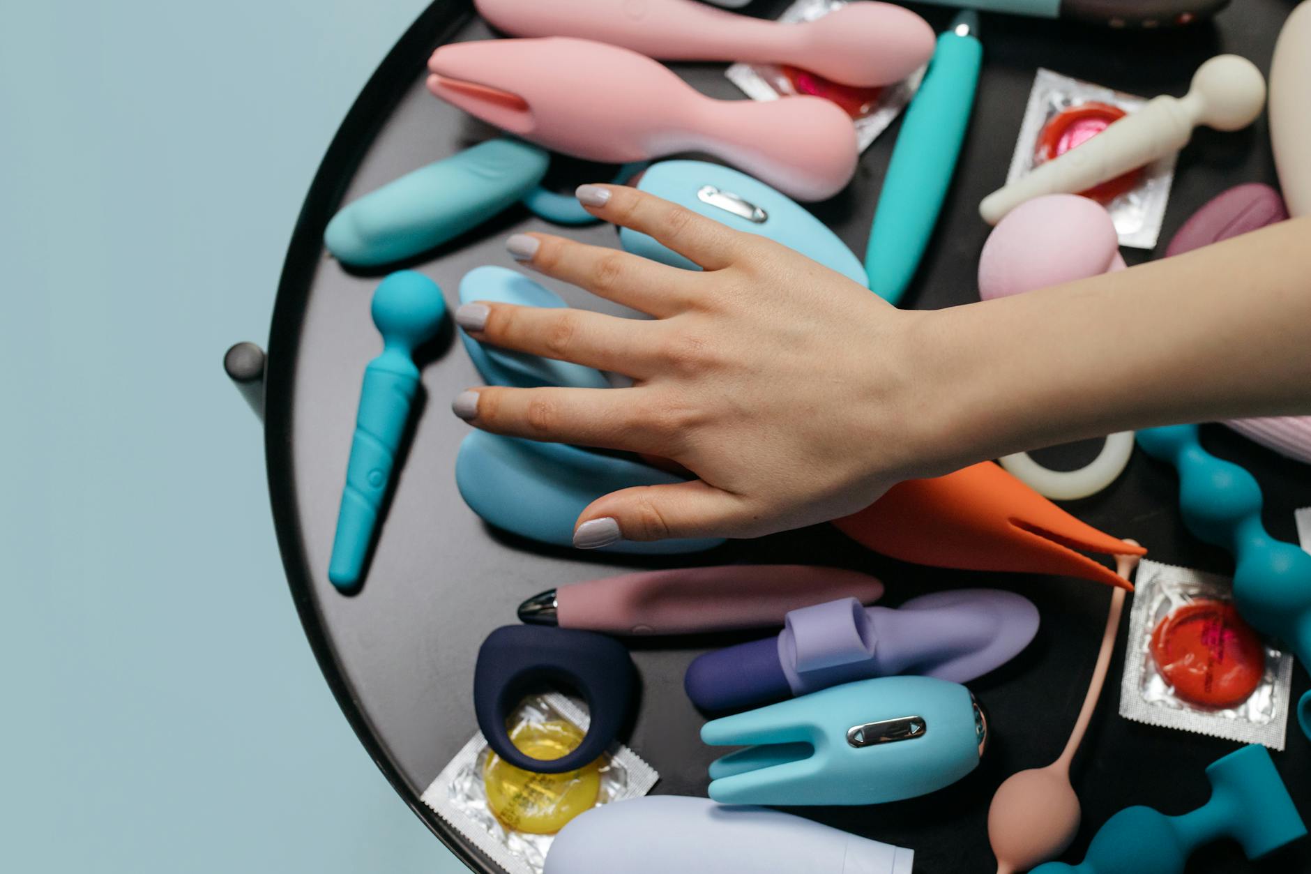 Woman holding clitoral vibrators with a thoughtful expression