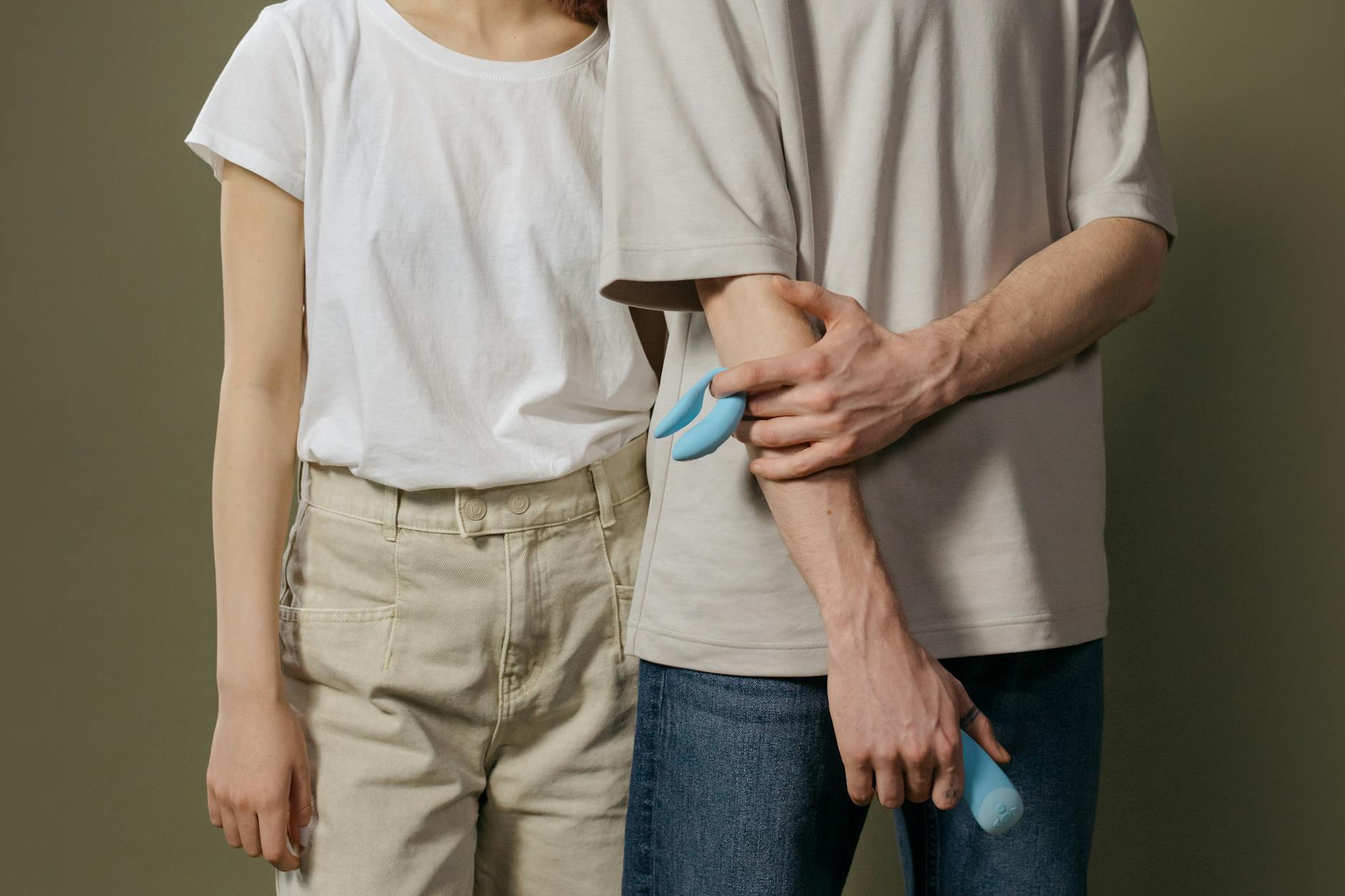 A couple holding a modern clitoral vibrator together, representing intimate connection and pleasure in midlife